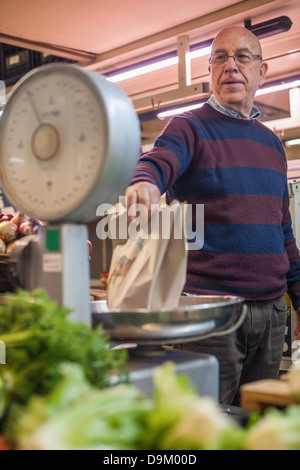 Ladenbesitzer mit einem Gewicht von frischem produzieren im Markt Stockfoto