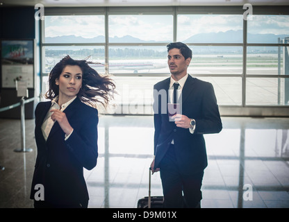 Geschäftsleute, die im Flughafen laufen Stockfoto