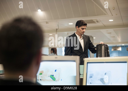 Security Guard Überprüfung Gepäck auf Monitor im Flughafen Stockfoto