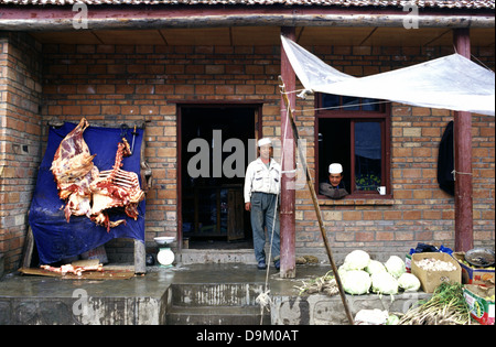 Hui chinesische Männer verkaufen Fleisch an der kleinen Alpenstadt Langmusi am östlichen Rand der Qinghai Plateau, eingebettet in einem Tal zwischen den Provinzen Gansu und Sichuan in China gemeinsam genutzt Stockfoto