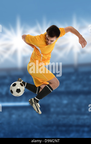 Fußball-Spieler durchführen Back Kick im Stadion in der Abenddämmerung Stockfoto