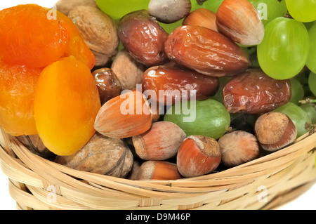 Schließen Sie auf getrockneten Früchten und Trauben in einem Korb Stockfoto