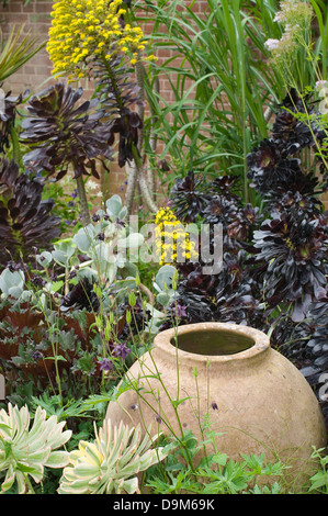 Garten-Design. Keramischer Vase zwischen Blumen. Stockfoto