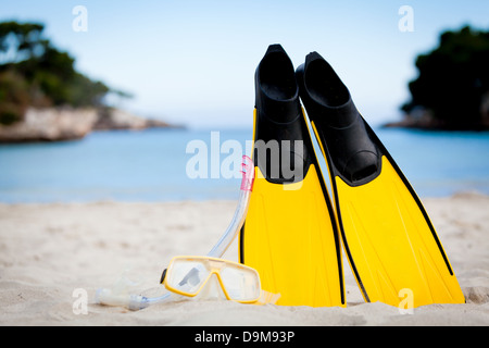 gelbe Flossen und Schnorchel Maske am Strand im Sommerurlaub Stockfoto
