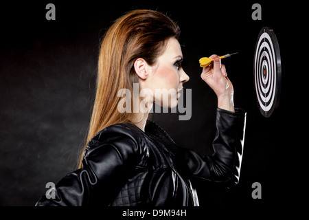 Punk-Mädchen mit Dart Pfeil und Ziel schwarz backgruond Stockfoto