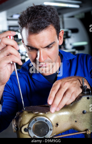 Mechaniker reparieren Industrienähmaschine Stockfoto