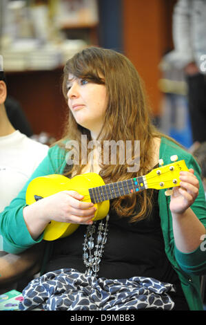 Blackwells Bookshop, Charing Cross Road, London, UK. 22. Juni 2013. Eine junge Frau erfährt man auf der "Ukulele-Party" im Blackwells Bookshop eine Tätigkeit als Bestandteil der Charing Cross Road Fest 2013 die Ukulele zu spielen. Bildnachweis: Matthew Chattle/Alamy Live-Nachrichten Stockfoto