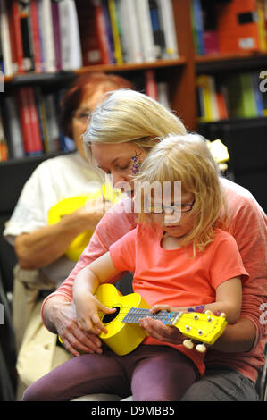 Blackwells Bookshop, Charing Cross Road, London, UK. 22. Juni 2013. Eine Mutter und ihre Tochter lernen, die Ukulele spielen bei der Ukulele-Party im Blackwells Bookshop eine Tätigkeit als Bestandteil der Charing Cross Road Fest 2013. Bildnachweis: Matthew Chattle/Alamy Live-Nachrichten Stockfoto