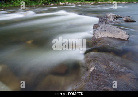 Langzeitbelichtung ein Fluss fließt über die Felsen mit seidig fließend Wasser Stockfoto