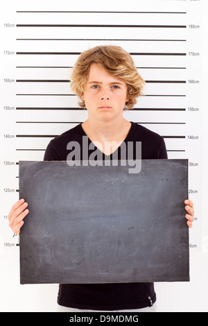 Teenager mit einer Tafel unter kriminellen Fahndungsfoto Stockfoto