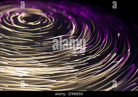 Kreisförmiges Muster aus violettem und weißem Lichtwellenleiter-Licht Stockfoto