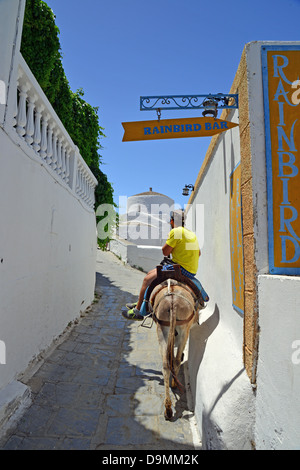 Lokale Mann Reiten Esel, Lindos, Rhodos (Rodos), die Dodekanes, South Aegean Region, Griechenland Stockfoto