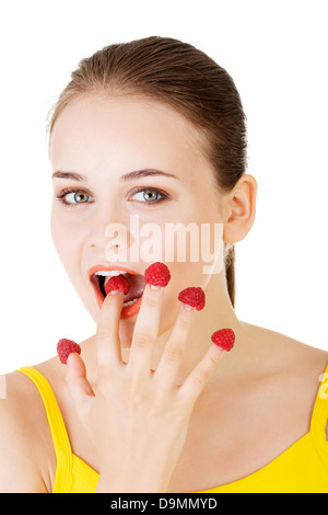 Lächeln lässige Frau mit Himbeeren, isoliert auf weiss. Stockfoto