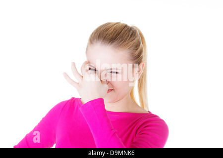 Frau deckt Nase mit der Hand zeigen, dass etwas stinkt, isoliert auf weiss, Stockfoto