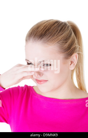 Frau deckt Nase mit der Hand zeigen, dass etwas stinkt, isoliert auf weiss, Stockfoto