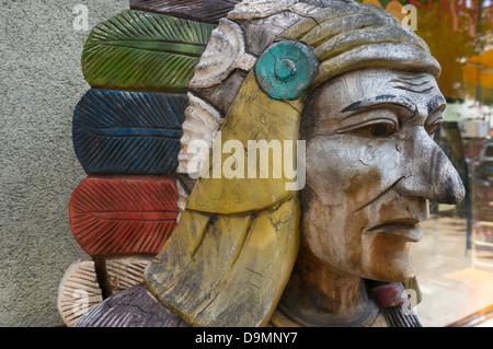 Zigarre – Store Indian geschnitzt aus Holz mit einer Feder Kopfschmuck, wahrscheinlich Lakota-Sioux Stockfoto