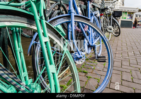 Grün und lila Fahrräder eine Amsterdam-Kanal entlang. Amsterdam, NL. Stockfoto
