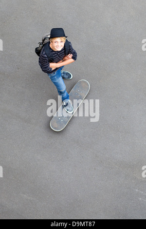 Happy Teen Skateboarder auf Skateboard stehen und nach oben schauen Stockfoto