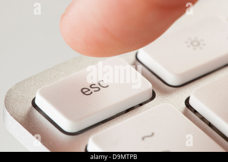 Finger auf einer weißen und grauen Computertastatur Escape drücken Stockfoto