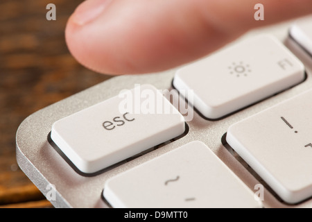 Finger auf einer weißen und grauen Computertastatur Escape drücken Stockfoto