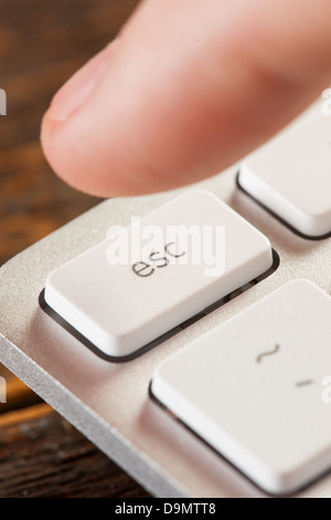 Finger auf einer weißen und grauen Computertastatur Escape drücken Stockfoto