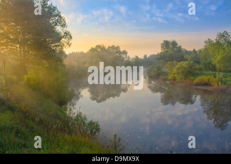 Sommerlandschaft mit Sonnenaufgang über dem Fluss Stockfoto