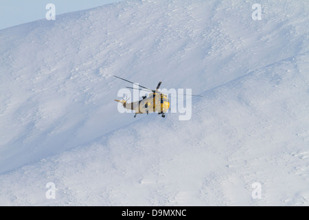 Rettungshubschrauber über Caringorm Berge. Highland. Schottland Stockfoto