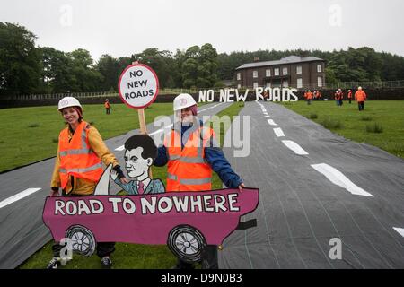 Cheshire, UK. 23. Juni 2013. Natalie Hynde Daughter von Chrissie Hynde und Ray Davies und Gabriele Join 20 Aktivisten gekleidet in Roadbuilders hoch, nämlich Kleidung, Roll-out einer gefälschten Straße im Bereich direkt unterhalb der Klippe Hall, Cheshire, auf dessen Gelände der Schatzkanzler George Osborne einen Wohnsitz hat. Der Protest wurde vorgenommen, um die erwartete Freigabe von Geld für Wegebau Regelungen im gesamten Vereinigten Königreich in die bevorstehenden Ausgaben Reivew am Mittwoch, den 26. Juni markieren Credit: Adrian Arbib/Alamy Live-Nachrichten Stockfoto