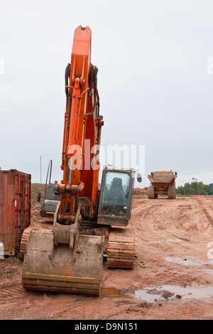 Industrielle Erde Bagger mit Muldenkipper im Hintergrund an einer Straßenbaustelle Stockfoto