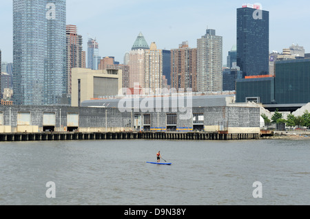 Stand up Paddler auf dem Hudson River mit Midtown Manhattan im Hintergrund. Stockfoto