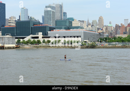 Stand up Paddler auf dem Hudson River mit Midtown Manhattan im Hintergrund. Stockfoto