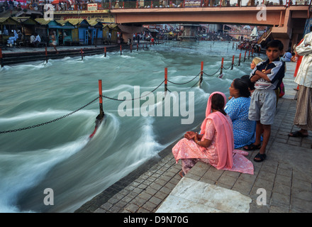 Indische Pilger sitzen am Ufer des Flusses Ganges, Har Ki Pauri Ghat, Haridwar, Uttarakhand, Indien Stockfoto