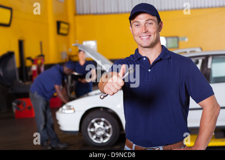 glücklich männliche Automechaniker geben Daumen halten Schraubenschlüssel Stockfoto