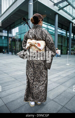 Sanshin - drei stringed traditionelles Musikinstrument aus Okinawa angezeigt wird von einem japanischen Frauen tragen einen Kimono-Bademantel Stockfoto