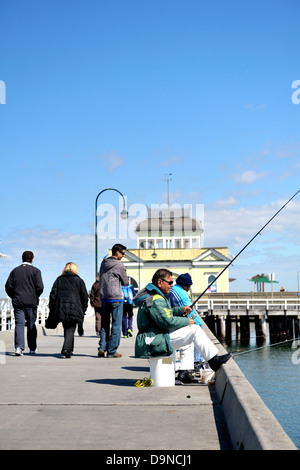 Fischer auf dem St Kilda Pier mit dem St Kilda Pavilion im Hintergrund. St Kilda, Melbourne, Victoria, Australien Stockfoto