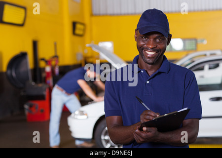 männliche afrikanische amerikanische Fahrzeug-Mechaniker Bericht schreiben Stockfoto