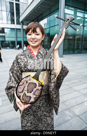 Sanshin ein drei stringed traditionelles Musikinstrument aus Okinawa angezeigt wird von einem japanischen Frauen tragen einen kimono Stockfoto