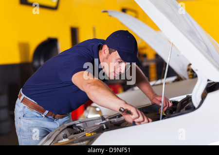 Kfz-Mechaniker reparieren Fahrzeug in Werkstatt Stockfoto