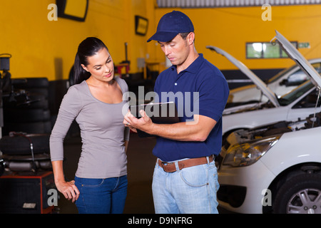 Kfz-Mechaniker und junge Frau Kunden in Werkstatt Stockfoto