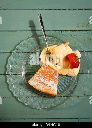 Zitronenkuchen mit Zitronencreme auf Glasplatte mit Erdbeere Stockfoto