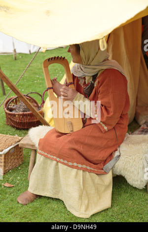 Reenactment des Lebens in ein Wikingerdorf, Frau spielen Musikinstrument, Peterborough Heritage Festival 22. Juni 2013, England Stockfoto