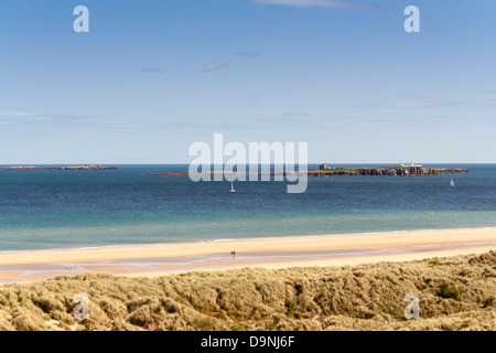 Ansicht der Farne Islands von Strand und Küste von Northumberland. Ein schöner sonniger Tag, zeigt Yachten und ein Walker übernahm. Stockfoto