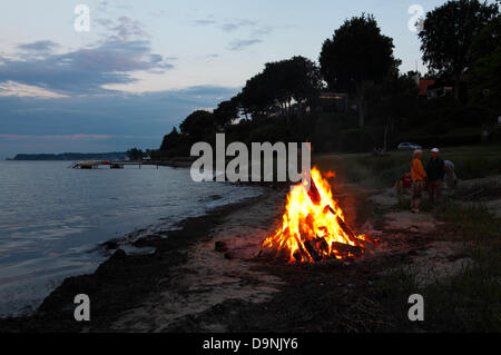 23. Juni 2013 – Skodsborg, nördlich von Kopenhagen, Dänemark. St. John es Eve, die Johannisnacht oder Sankthansaften in Dänemark wird von brennenden Lagerfeuer bei Sonnenuntergang gefeiert. Stroh und Rag Hexe wird auf das Feuer gelegt, bevor es leuchtet. Dann ist es Zeit für das traditionelle Rede und Johanni-Lied.  Die Lagerfeuer-Anordnung sind einschließlich einer kulturellen Rede von einer bekannten Person und das traditionelle Mittsommer-Lied singen von den meisten Kommunen im ganzen Land statt. Aber lokale Freudenfeuer und Parteien sind vor allem entlang der Küste fast überall angeordnet. © Stockfoto