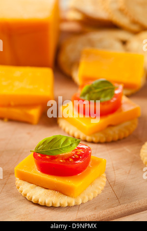 Chedder Käse und Cracker Vorspeise mit Tomaten und Basilikum Stockfoto