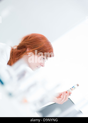 verschwommene Lab Seitenansicht einer Frau Analyse Pillen in einem Rohr Stockfoto