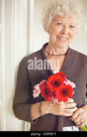 Glücklich senior Frau mit einem Bouquet von frischen Blumen Stockfoto