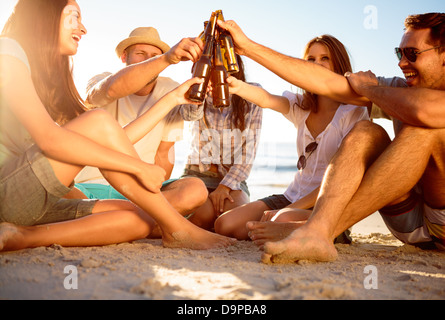 Freunde, die Sie auf ihre Flaschen Bier am Strand Stockfoto