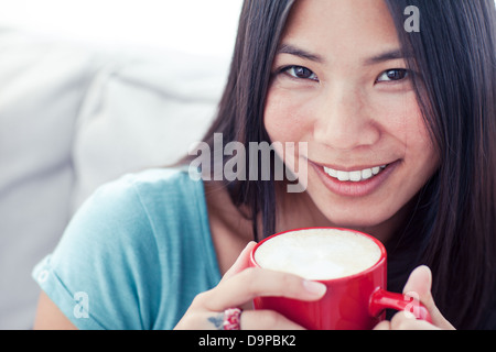 Ziemlich asian Frau hält einen Becher Kaffee Stockfoto