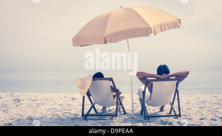 Menschen entspannen und lehnen sich auf Liegestühlen Stockfoto