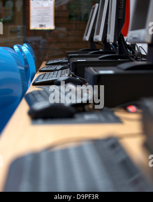 Eine Bank von Desktop-Computern und Tastaturen in einer Schule IKT-suite Stockfoto